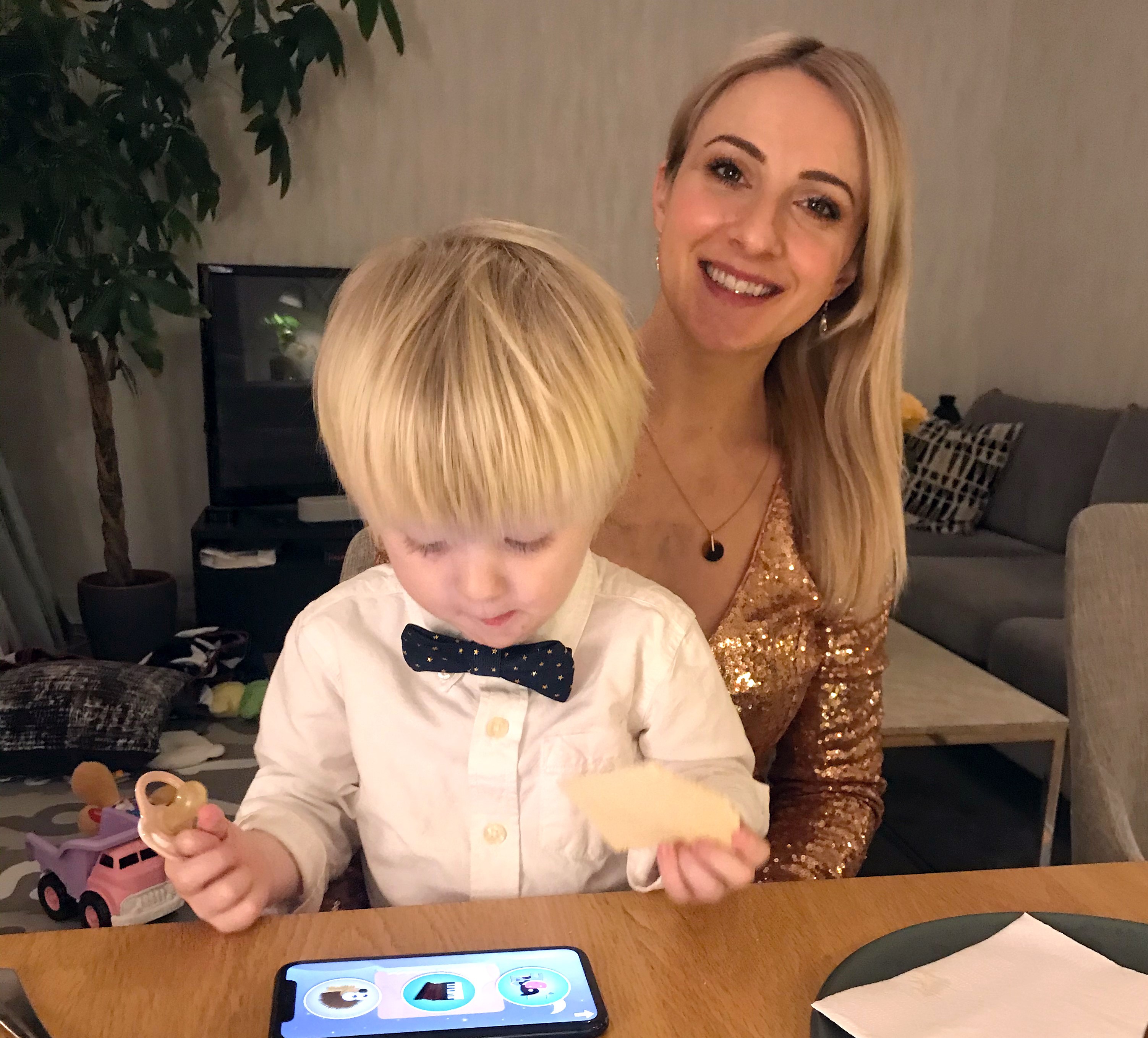 Iris Classon in a sparkly dress and big smile celebrating NYE with her son